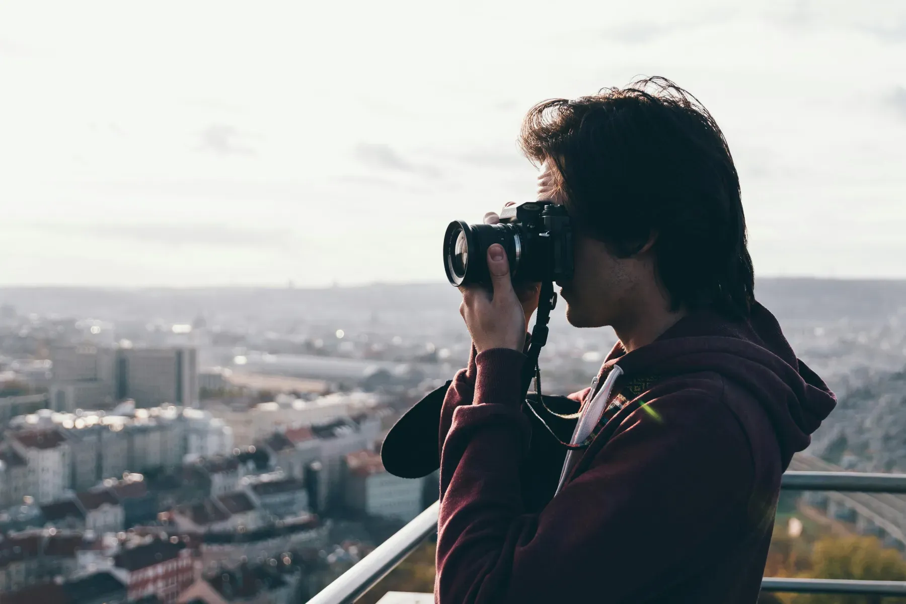 Creator fotografiert mit einer Kamera über den Dächern einer Stadt